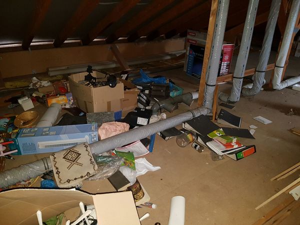Dachboden mit vielen gelagerten Gegenständen, Kartons, Aktenordnern und Hausrat.