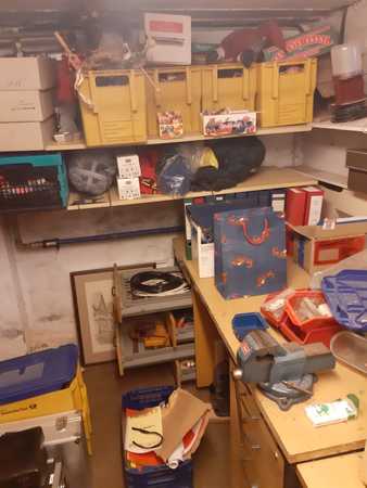 Werkstatt mit Regalen, Werkzeugen, gelben Kisten und verschiedenen Bastelmaterialien.