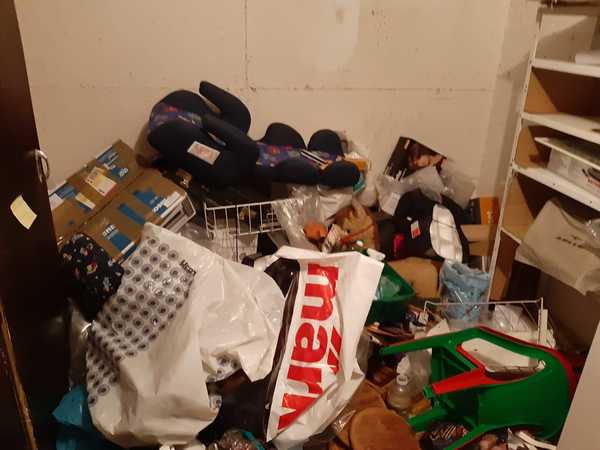 Abstellraum mit Kartons, Tüten, Regalen und verschiedenen Haushaltsgegenständen vollgestellt.